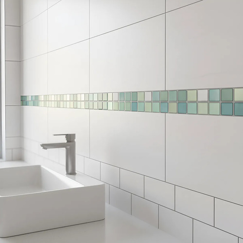 Guarda autoadhesiva 3D verde claro instalada en pared de baño blanca, junto a lavamanos y grifo